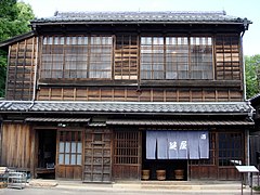 Lowest roof is wood. Other popular flammables to hang under the eaves include noren curtains, rice straw ropes and paper streamers (religious), balls of dried sugi leaves (to advertise sake), thin wood signage, blinds, and paper lanterns.