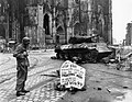 Cpl. Luther E. Boger, Concord, N.C., skytrooper, reads a warning sign in the street. Cpl. Boger is with the 82nd Airborne Division. 4 April 1945.