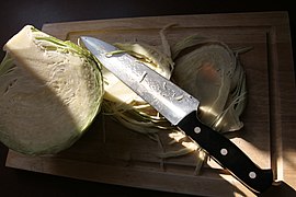 Kitchen knife made of stainless steel with sliced white cabbage.jpg