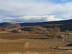 Panorámica rural de Palomar de Arroyos, Teruel. Ermita de El Salvador, tierras de cultivo, parque eólico.jpg