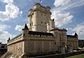 The 14th-century keep of Château de Vincennes near Paris towers above the castle's curtain wall. The wall exhibits features common to castle architecture: a gatehouse, corner towers, and machicolations.