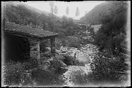 Dos homes pescant al costat d'un edifici a la riba de la Tordera.jpeg