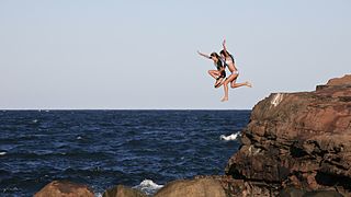 Australian girls jumping into ocean