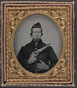 Unidentified cavalry soldier in Union frock coat with Remington New Model Army revolver LCCN2011660348.jpg