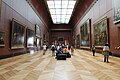 Visitantes del Museo del Louvre contemplando los cuadros de grandes dimensiones de Jacques-Louis David (a la izquierda El juramento de los Horacios, a la derecha La consagración de Napoleón y Las sabinas) en 2016.