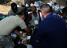 US Navy 100119-N-7948C-048 A Haitian woman screams in pain as U.S. military medical personnel try to set her broken leg at a clinic at the Killick Haitian Coast Guard Base.jpg