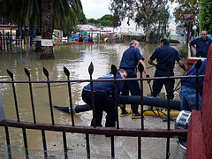 US Navy 081011-N-0000P-003 irefighters from Naval Station Rota connect hoses to a pumper truck to remove floodwaters from a park in Rota, Spain.jpg