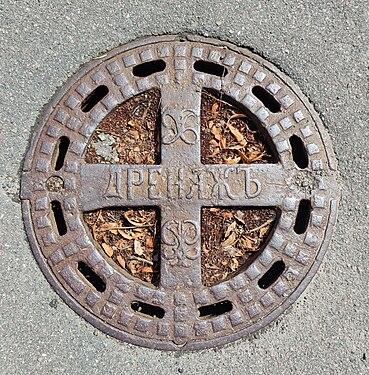 Old manhole cover in St. Petersburg with pre-revolutionary spelling