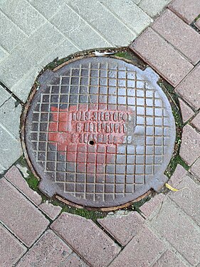 Old manhole cover in St. Petersburg with pre-revolutionary spelling