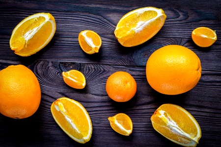 Sliced oranges for lunch on dark wooden desk background top view pattern Stock Photo