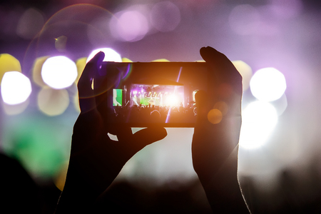 Shoots a video on a mobile phone at a concert Stock Photo