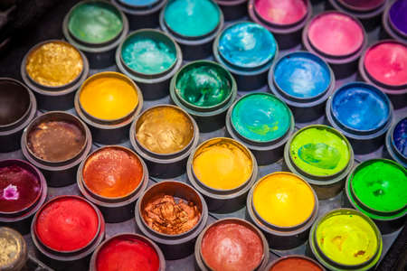 Colorful paint tubes on a table with paints used for face art Stock Photo