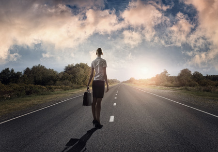 Young businesswoman standing on road and choosing her way