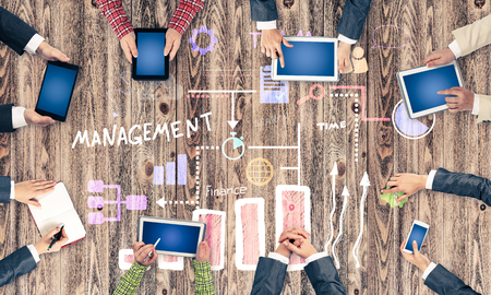 Group of people with devices in hands working together as symbol of networking and communication