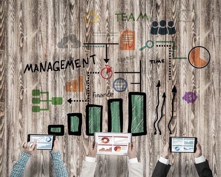 Group of three people with devices in hands working together as symbol of networking and communication Stock Photo