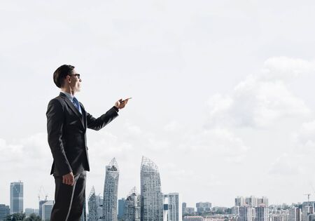 Young elegant businessman with pen in hand looking away