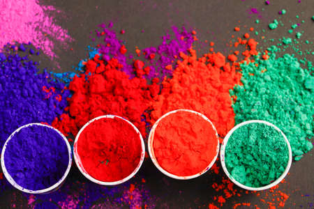 Indian festival holi multi color s cup on dark background