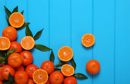 Tangerines with green leaves on turquoise wooden background top view Stock Photo