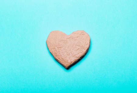 Heart from kraft cardboard paper on blue background concept zero waste protection of nature the environment eco friendly flat view from above