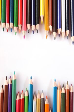 Many multi colored pencils lie in a row on a white background Stock Photo