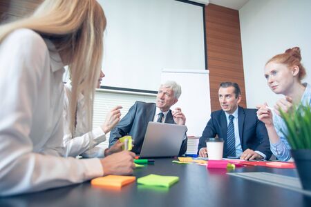 Working process at business meeting people sitting around office desk discussing ideas Stock Photo