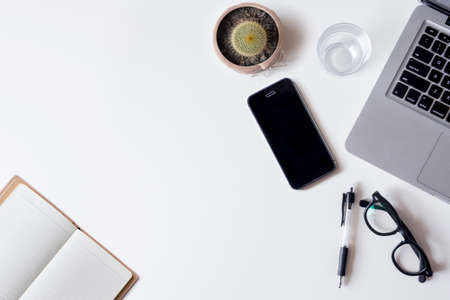 White office desk table with laptop smartphone notebook and glass top view with copy space flat lay Stock Photo