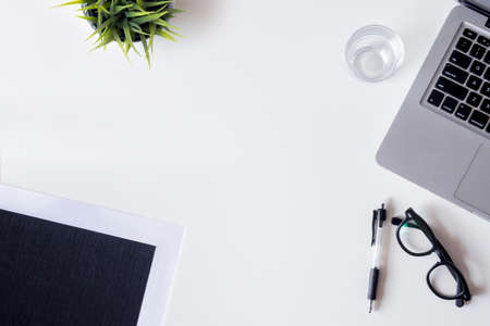 White office desk table with laptop smartphone file plan and glass top view with copy space flat lay