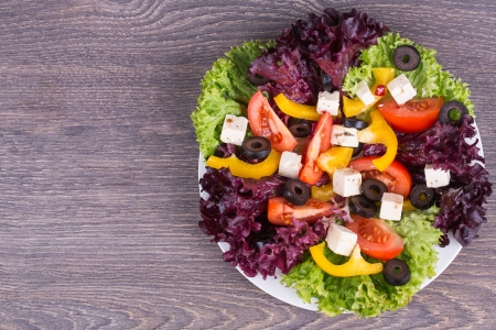 Fresh salad in white plate on wooden background Stock Photo