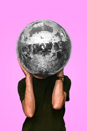 Man holds a disco ball mirror ball concept of a night club party club life nightlife