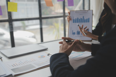 Financial analysts analyze business financial reports on a digital tablet planning investment project during a discussion at a meeting of corporate showing the results of their successful teamwork