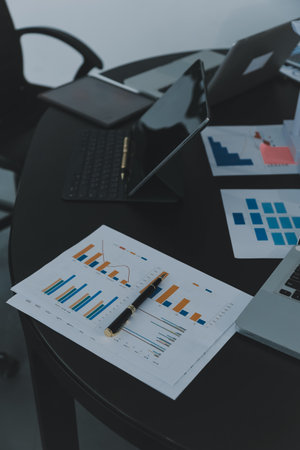 Close up of business team analyzing income charts and graphs with modern laptop computer business analysis and strategy concept