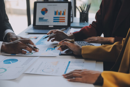 Financial analysts analyze business financial reports on a digital tablet planning investment project during a discussion at a meeting of corporate showing the results of their successful teamwork