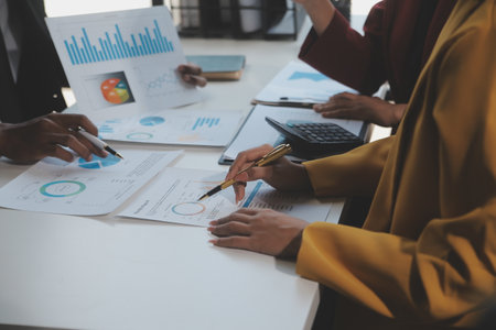 Financial analysts analyze business financial reports on a digital tablet planning investment project during a discussion at a meeting of corporate showing the results of their successful teamwork Stock Photo