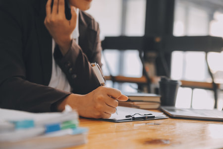 Empresaria asiática trabajando en una computadora portátil en la oficina con documentos en su escritorio haciendo planificación analizando el concepto de análisis de finanzas de inversión del plan de negocios del informe financiero Foto de archivo