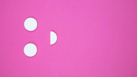 Composition of pills and capsules on a pink background in the form of a smile happy emotions psychological help good day