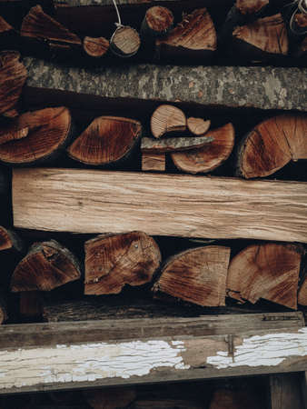 Pared de troncos de leña secos picados apilados uno encima del otro en un fondo de madera con textura de pila Foto de archivo