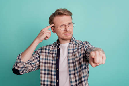 Thoughtful offensive guy direct finger call you stupid dumb isolated on teal color background