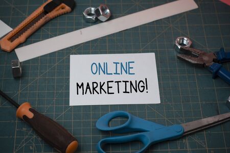 Handwriting text online marketing conceptual photo leveraging web based channels spread about companys brand carpentry equipments and plain paper scattered everywhere on measuring mat