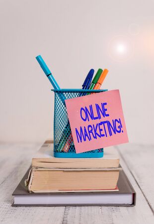 Word writing text online marketing business photo showcasing leveraging web based channels spread about companys brand stacked books pens metal holder sticky note lying vintage old wooden table Stock Photo