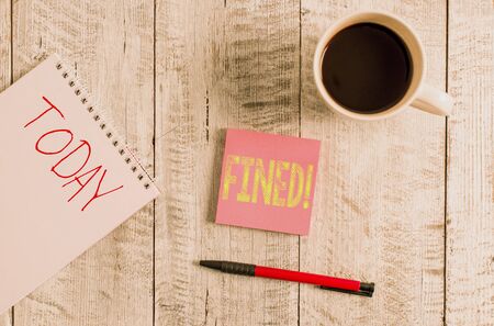 Writing note showing fined business concept for clarify beer by causing precipitation of sediment during production stationary placed next to a cup of black coffee above the wooden table