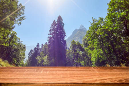 Mesa de madera vacía con fondo borroso del paisaje de verano en la zona de montaña. Se puede utilizar para exhibir o montar productos