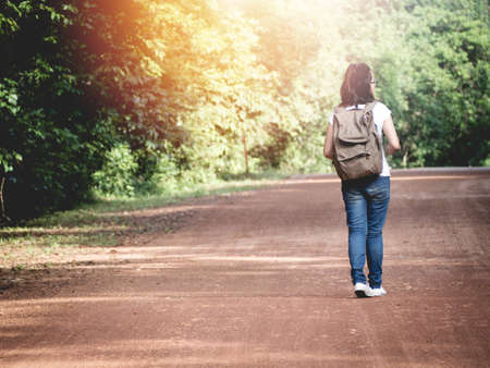 Young woman walking into woods wild adventure Stock Photo