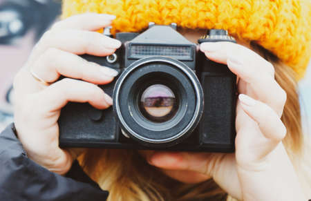 jong meisje fotograaf in een hoed met een vintage camera schiet frames Stockfoto