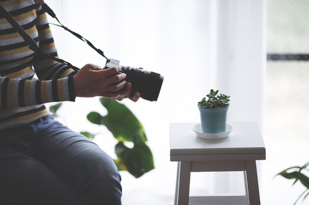 Woman photographing a plant indoors