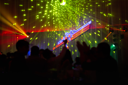 Blurred concept at concert party with audience and colourful led lighting