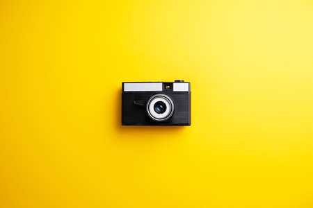 Vintage camera over yellow background
