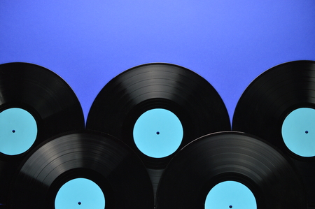 pila de viejos discos de vinilo negro con burbujas en blanco cian en el fondo azul Foto de archivo