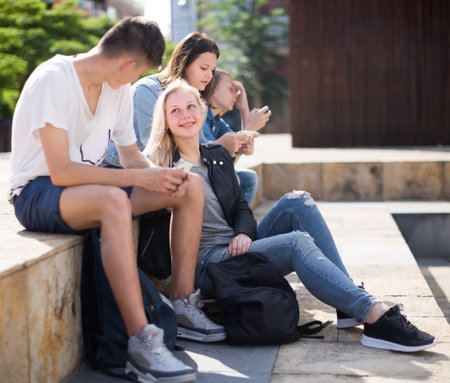 Modern teenagers communicate in schoolyard