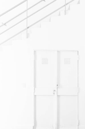 Interior space completely white wall door and staircase with handrail