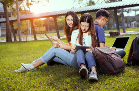 Students young asian together working study smiling with tablet laptop computer at university high school campus college in summer holiday relaxation